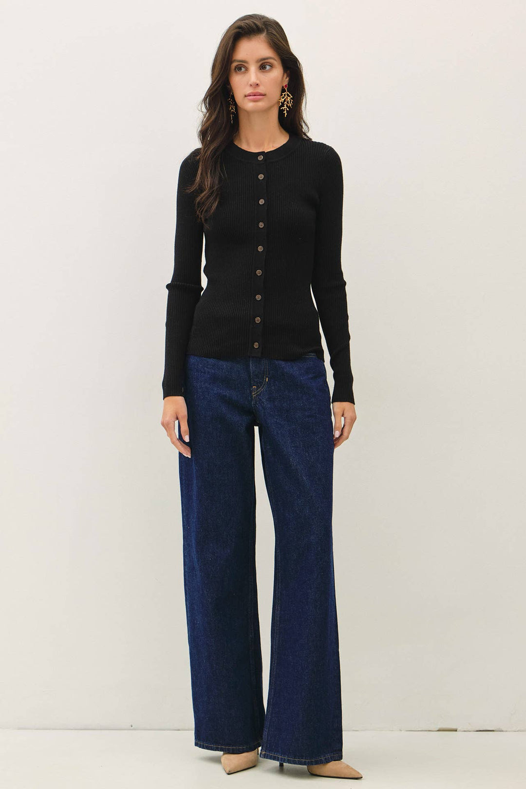 Model wearing a black CAL JUNE slim-fit ribbed cardigan with a crew neckline and button-front closure.