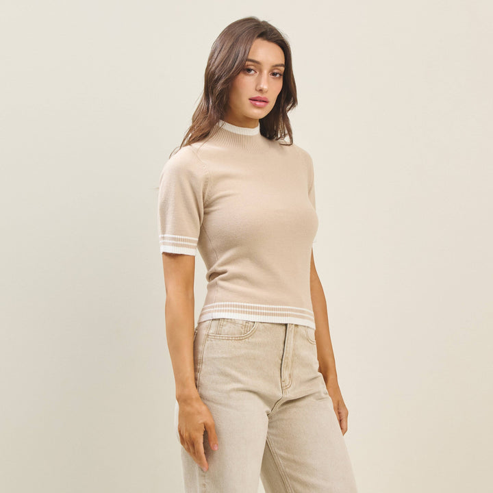 CAL JUNE The Arden Knit Top in beige with white trim on mock neck, sleeves, and hem. Short sleeves.