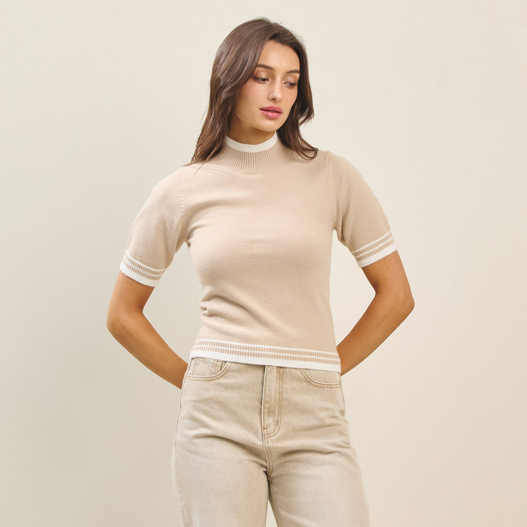 CAL JUNE The Arden Knit Top in beige, a short-sleeve mock neck sweater with white striped trim.