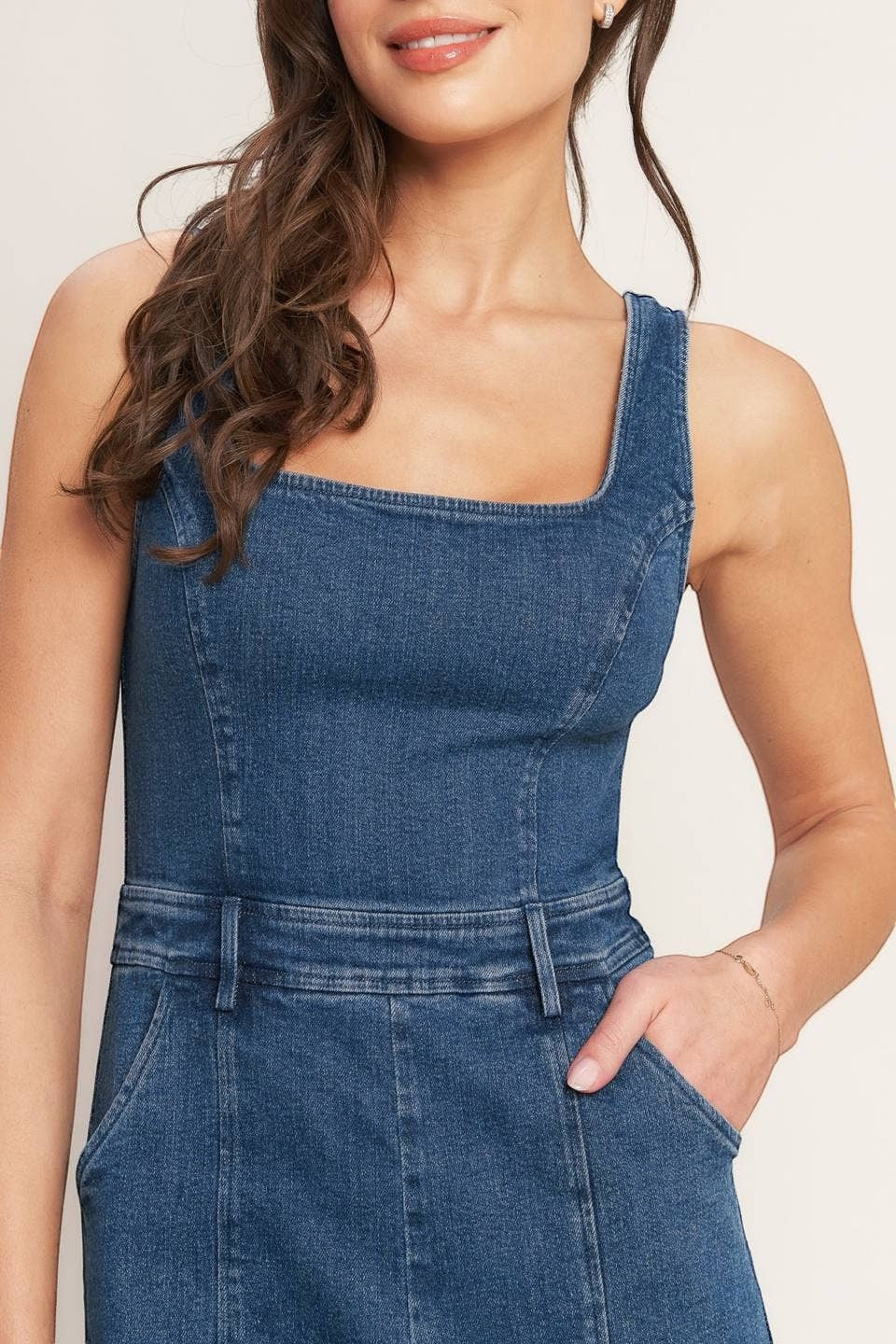 CAL JUNE Ari denim jumpsuit with square neckline and utility pockets. Model wears size Small.