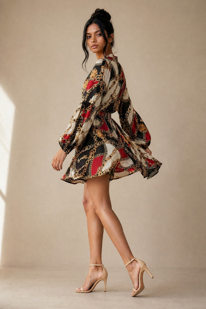 CAL JUNE Aria mini dress with chain print, V-neck, button front, drawstring waist, and balloon sleeves in black, white, red, and gold.