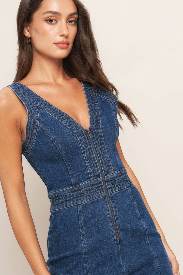 CAL JUNE Aurelia Denim Jumpsuit with V-neck and front zipper. Model is wearing size Small.