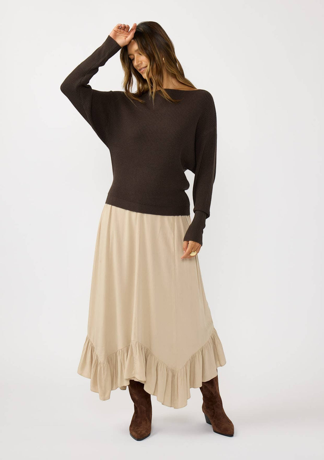 CAL JUNE The Avery Knit Top in dark brown, a ribbed boatneck sweater with dolman sleeves, paired with a beige ruffled midi skirt.