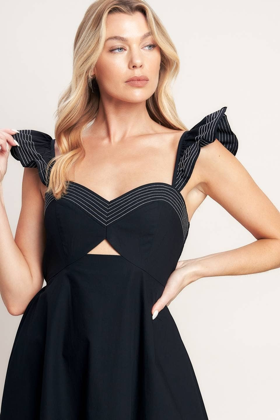 CAL JUNE black midi dress with sweetheart neckline, cut-out detail, and ruffled sleeves with white stitching.