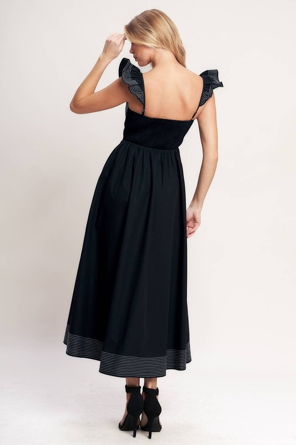CAL JUNE black midi dress with smocked bodice, ruffled straps, and contrast stitching detail on hem.