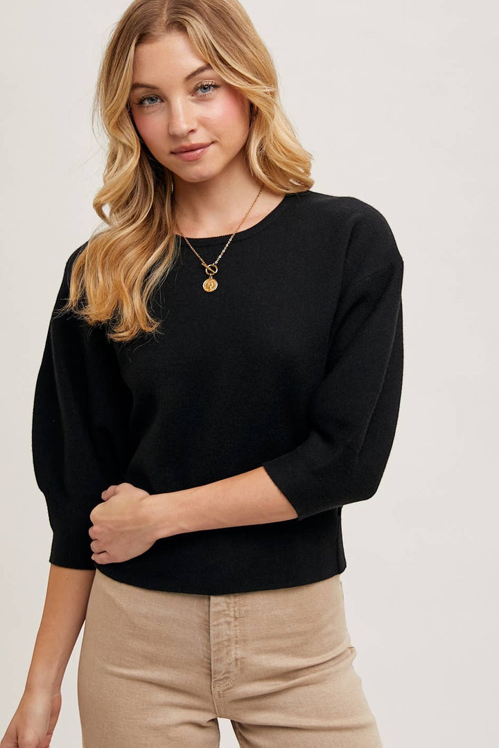 CAL JUNE black knit top with three-quarter puff sleeves and crew neck. Model wears size Small.