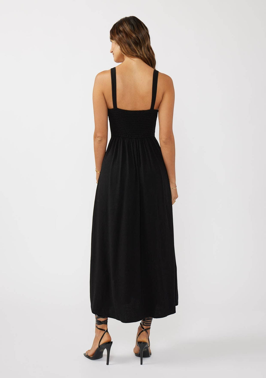 CAL JUNE black smocked bodice maxi dress with wide straps and flowing skirt. Model wears size S.