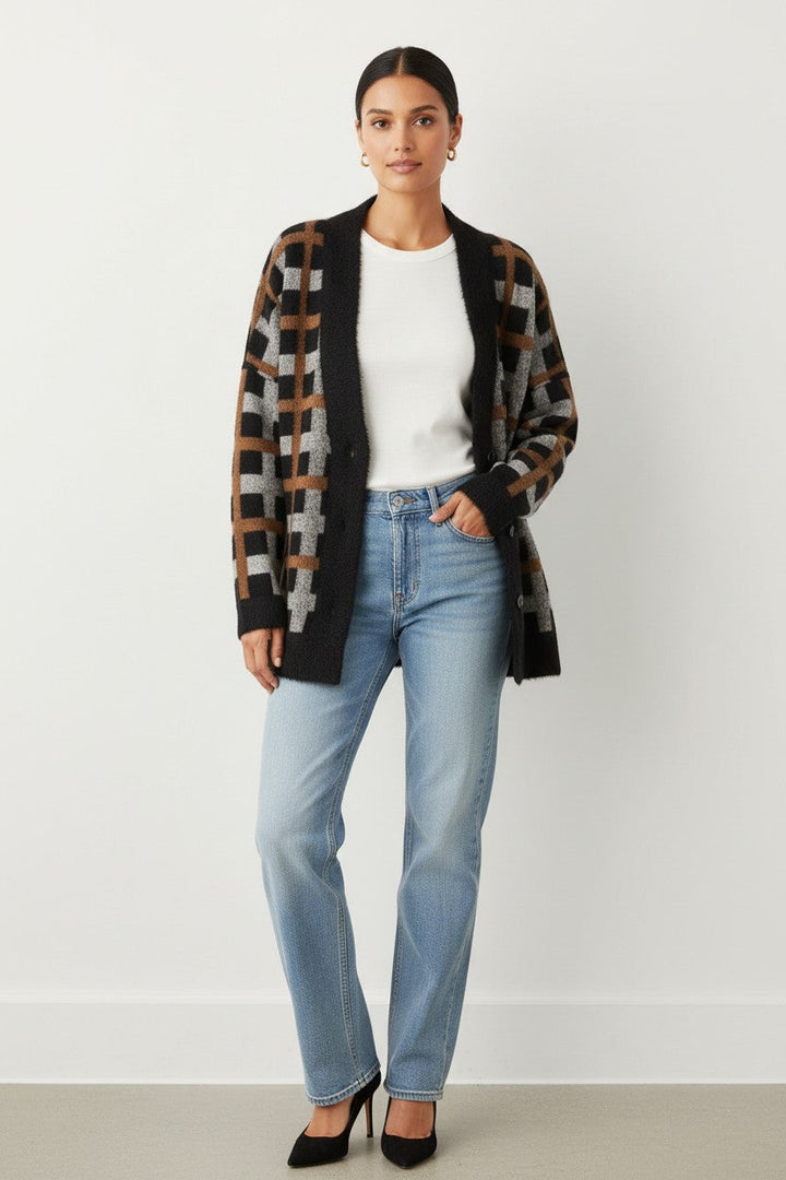 Model wearing a CAL JUNE Briseis oversized tri-color knit cardigan in black, brown, and grey over a white top.