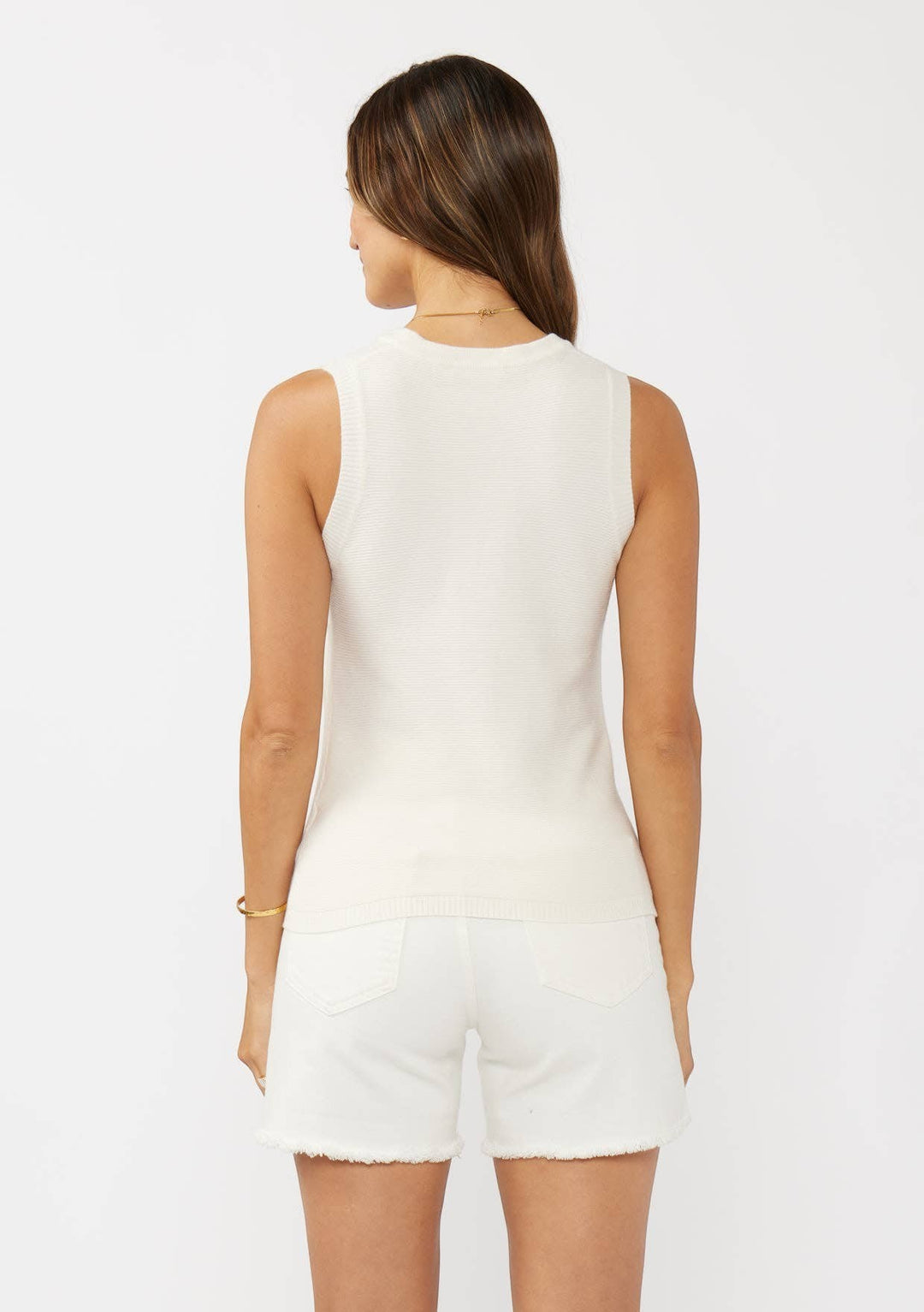 CAL JUNE cream ribbed knit sleeveless tank top on a woman wearing white denim shorts.