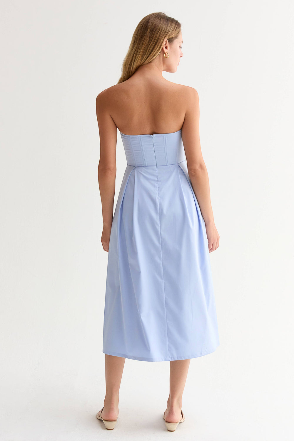 CAL JUNE Elara Strapless Midi Dress in light blue, featuring a structured bodice with boning and a pleated skirt. Model is 5'9".