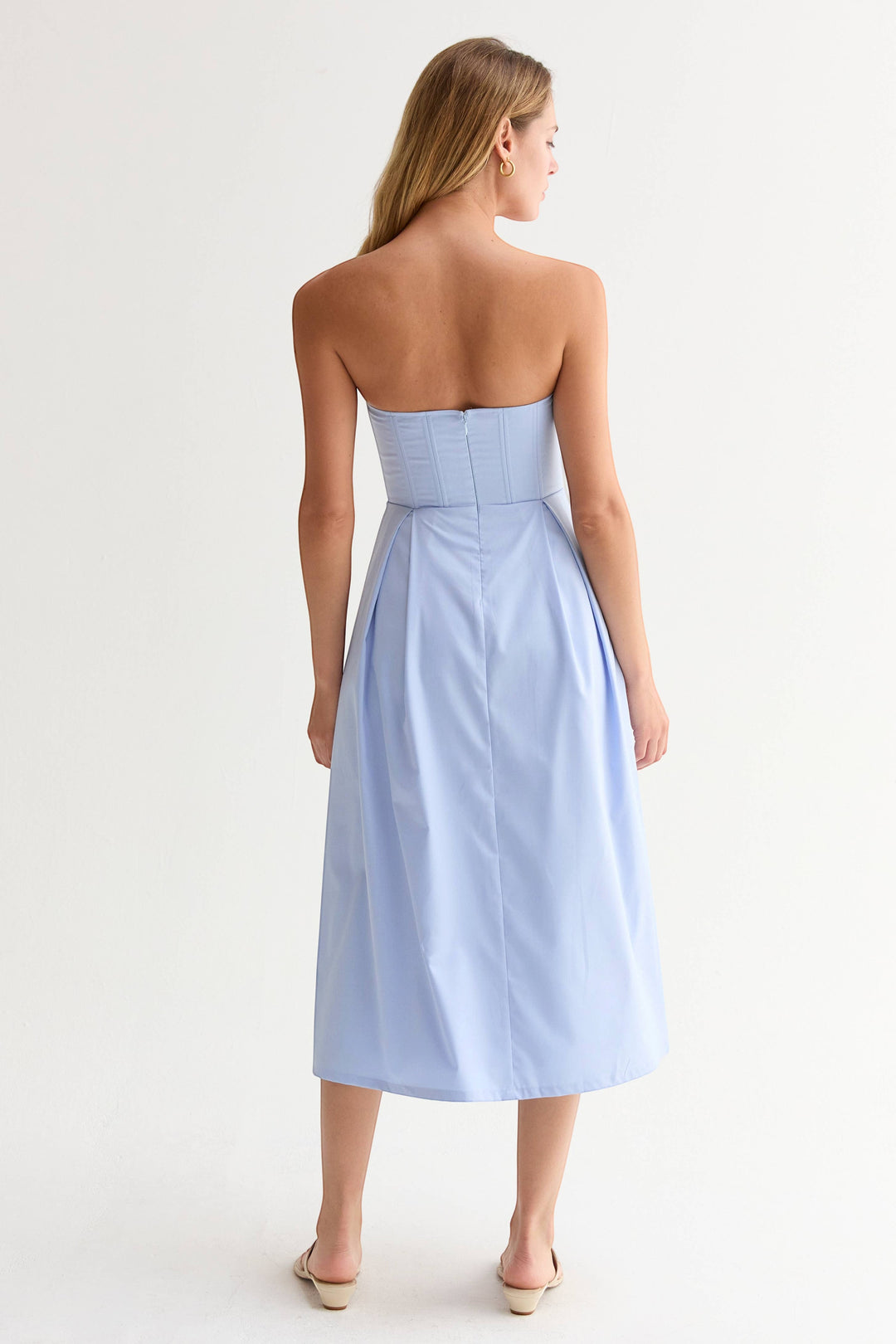 CAL JUNE Elara Strapless Midi Dress in light blue, featuring a structured bodice with boning and a pleated skirt. Model is 5&