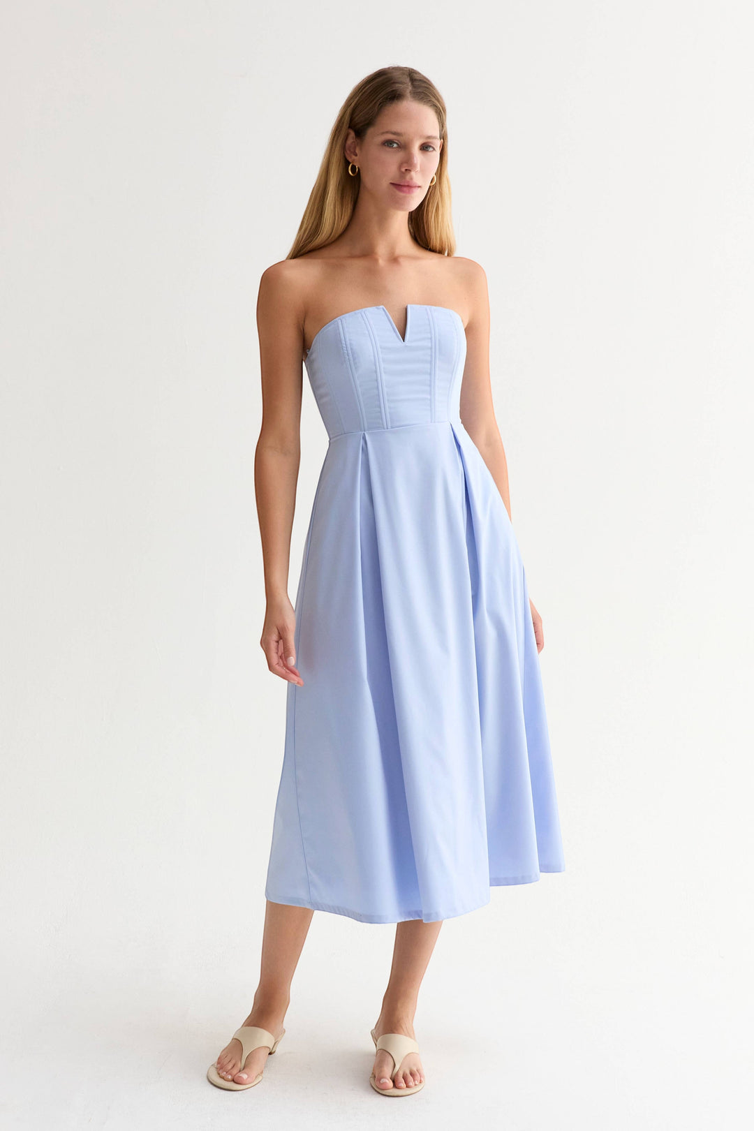 CAL JUNE Elara Strapless Midi Dress in light blue, featuring a structured bodice with V-wire neckline and pleated skirt.