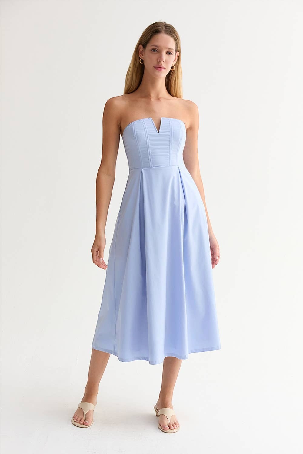 CAL JUNE Elara Strapless Midi Dress in light blue, featuring a sculpted bodice with V-wire detail and a pleated skirt.