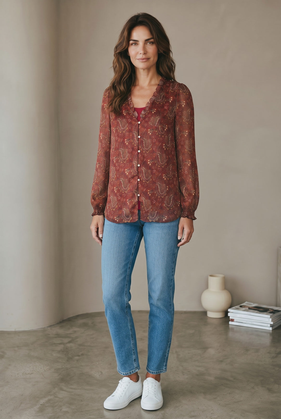 CAL JUNE The Elizabeth Ruffle Blouse in rust paisley print with ruffled neckline and button front. Model wears size S.