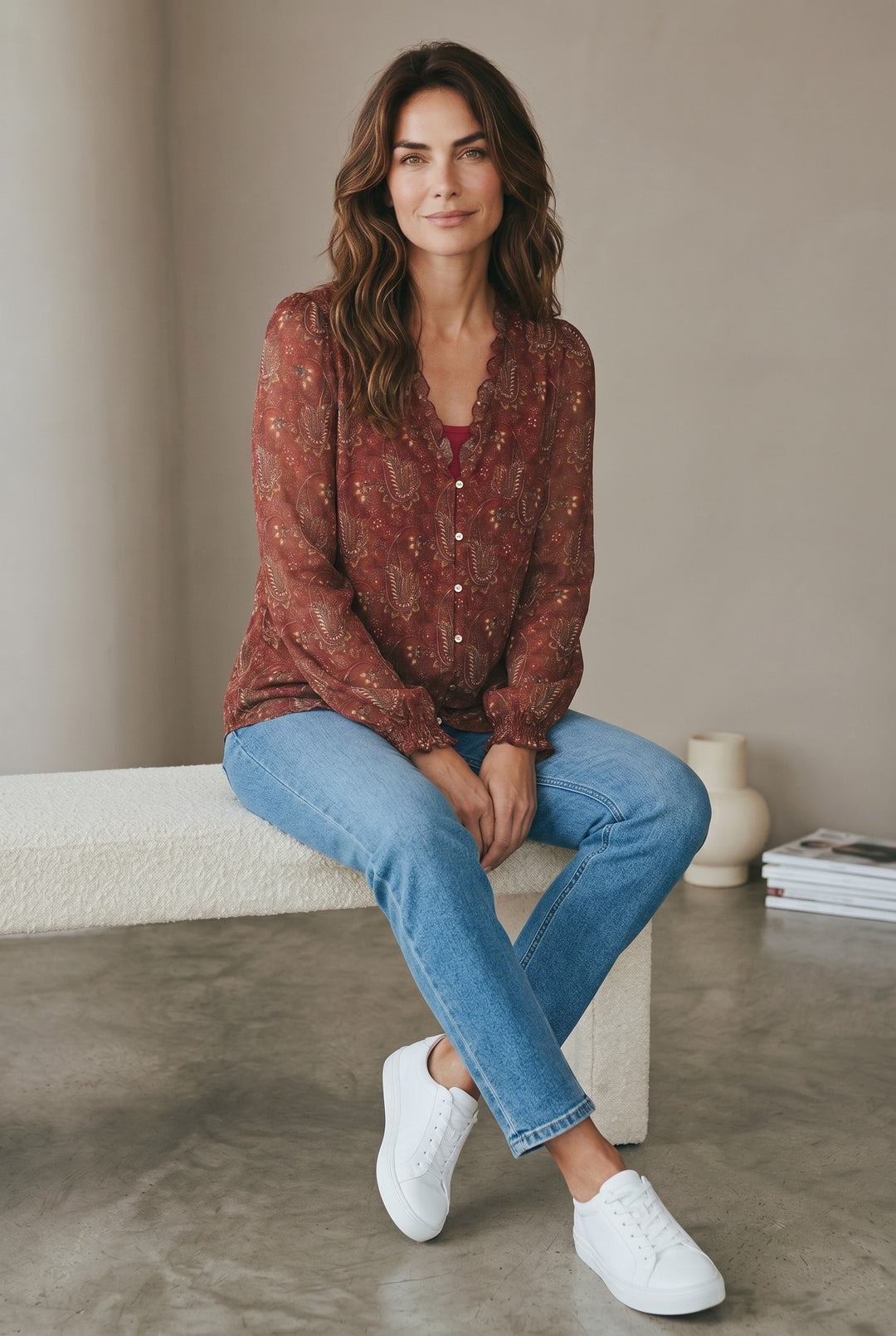 CAL JUNE The Elizabeth Ruffle Blouse in rust paisley print with ruffled neckline and button front. Model wears size S.