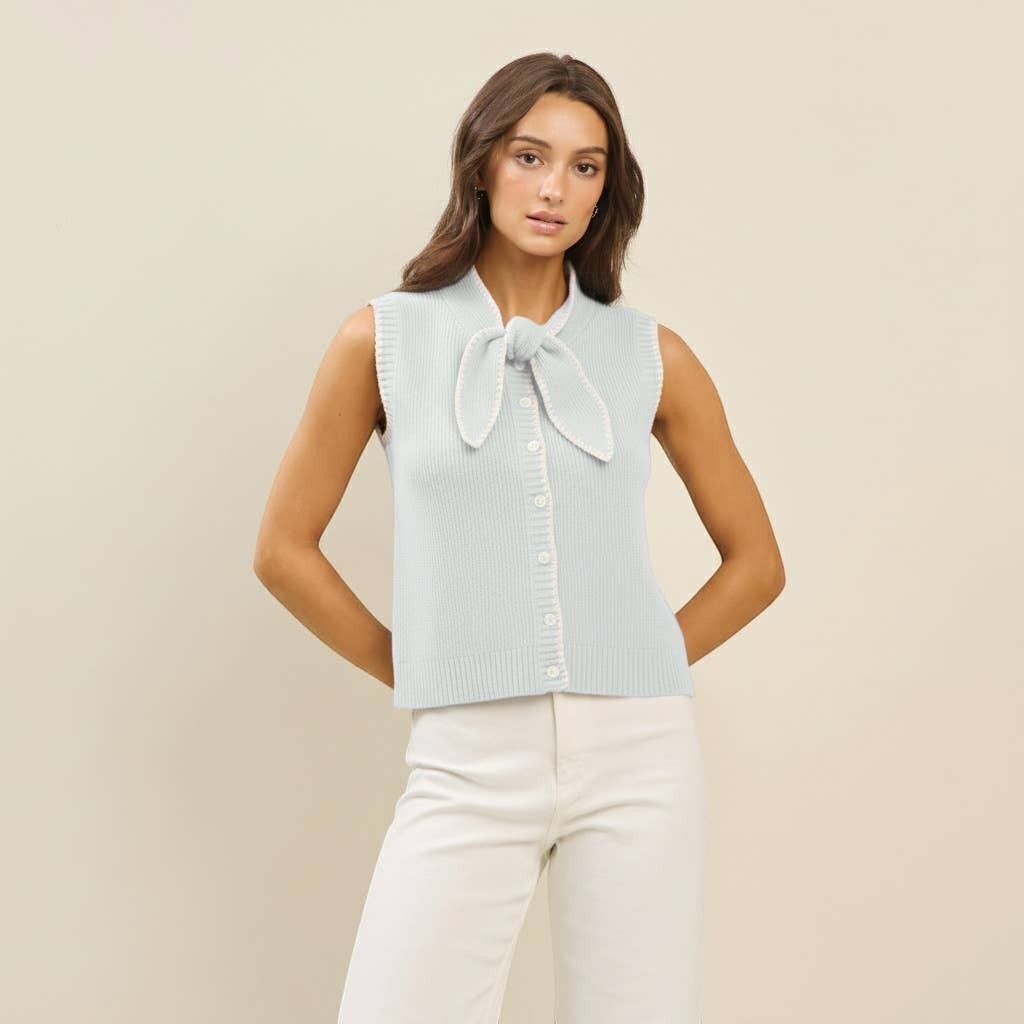 CAL JUNE light blue knit sweater vest with white whipstitch detailing and a tie neck. Model wears size Small.