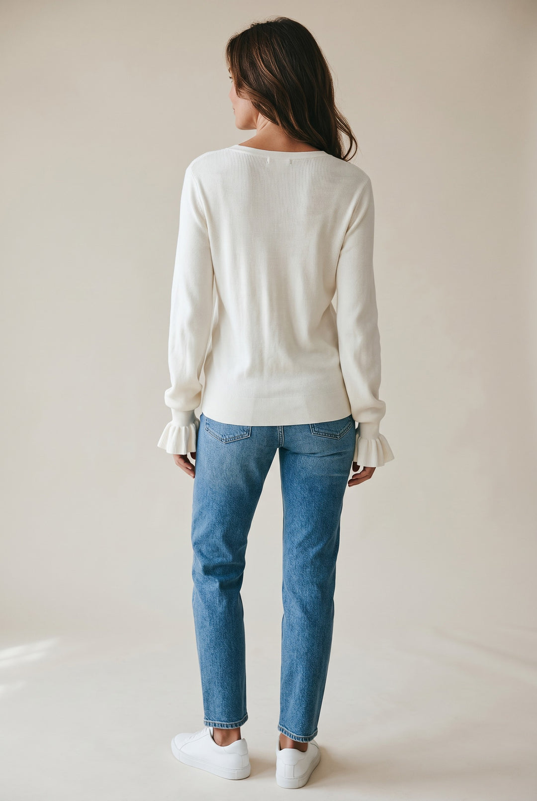 CAL JUNE The Louvre Ruffle Knit Top in ivory. Features ruffled cuffs and a relaxed fit.