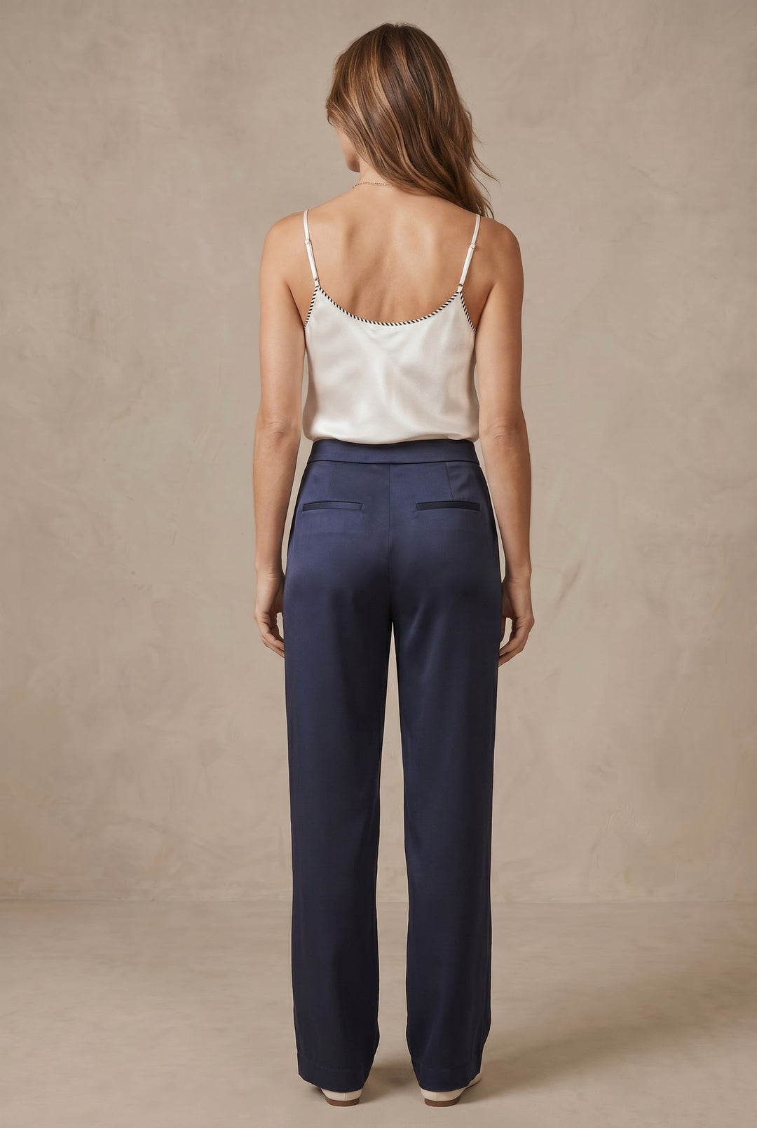 CAL JUNE cream lustrous camisole top with black whipstitch detail on straps and neckline, worn by a model.