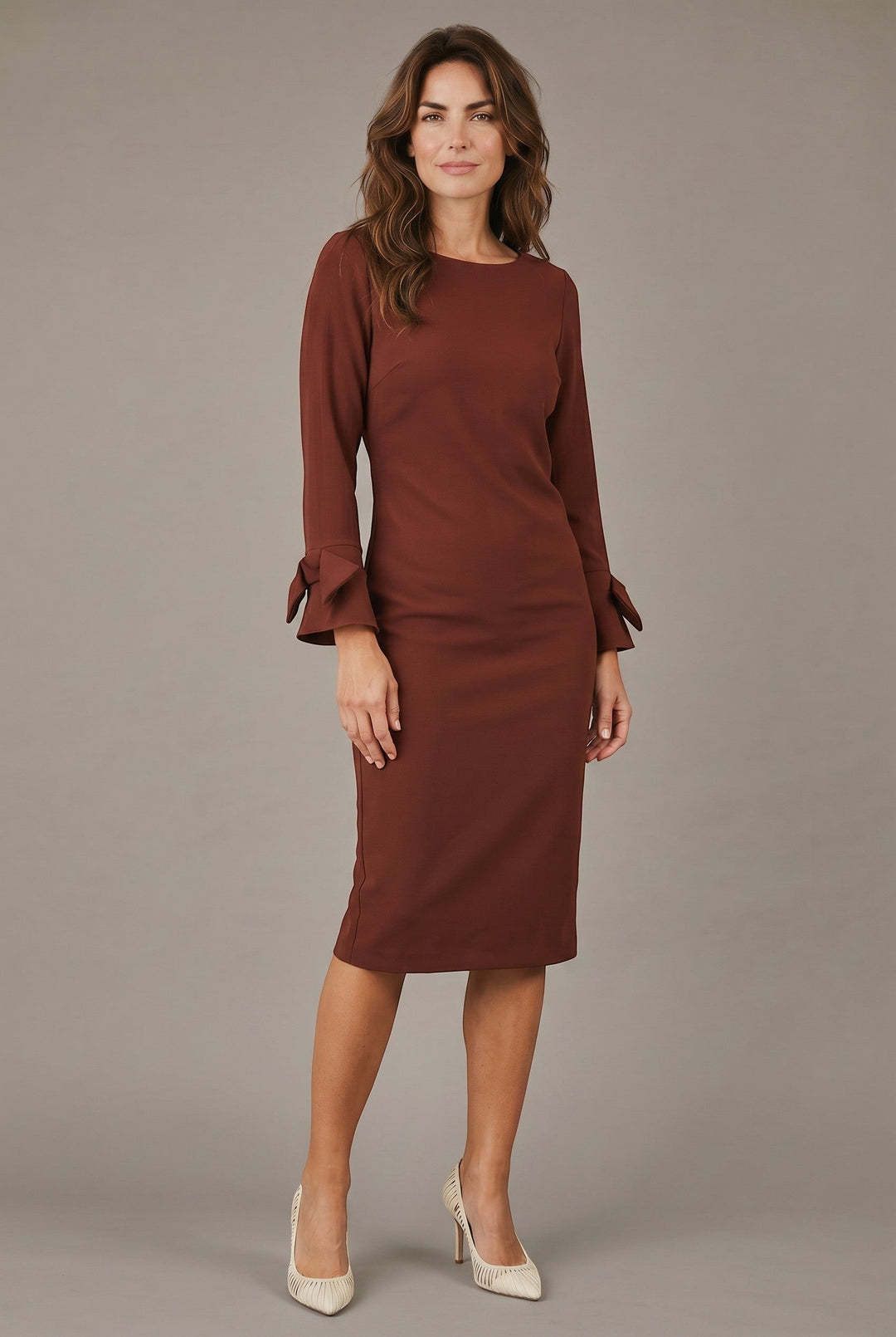 CAL JUNE The Sia Midi Dress in brown, featuring long sleeves with bow cuffs and a flattering sheath silhouette.