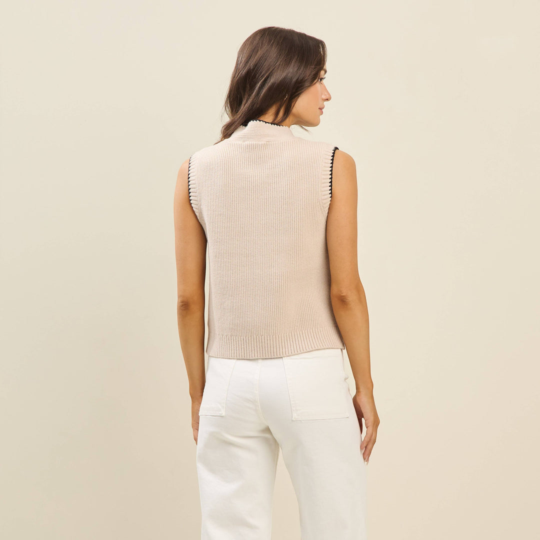 CAL JUNE Sienne sweater vest in beige knit with mock neck and whipstitch trim. Model wears size Small.