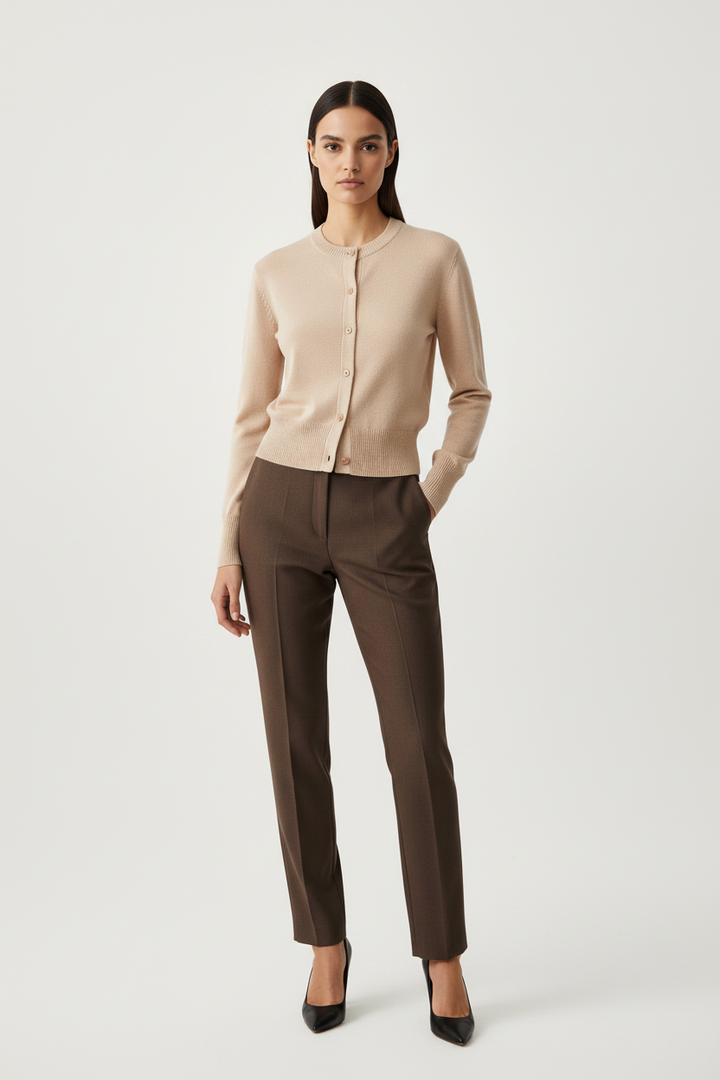 CAL JUNE Xiomara tan crewneck button-up cardigan in lightweight viscose knit worn with brown trousers and heels.