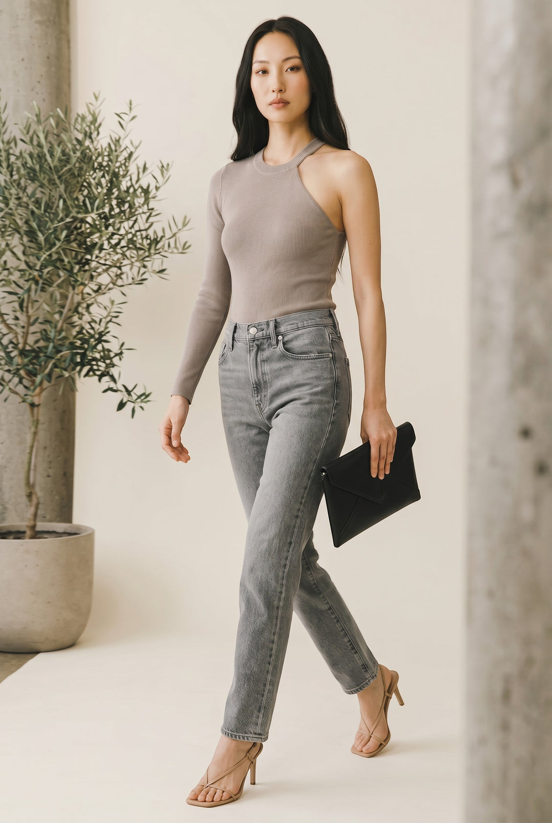 CAL JUNE taupe ribbed knit asymmetrical neckline top with one long sleeve and open shoulder, paired with light wash denim.