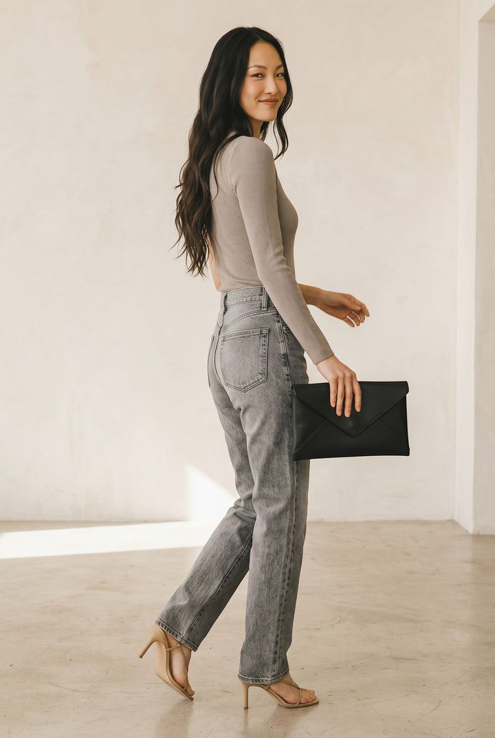 CAL JUNE taupe ribbed knit asymmetrical one-sleeve top with open shoulder. Model wears light wash jeans.