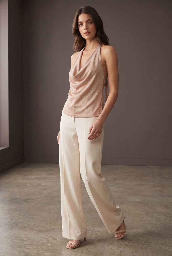 CAL JUNE Tessie halter top in rose gold metallic knit with cowl neck and low back. Model is wearing size Small.